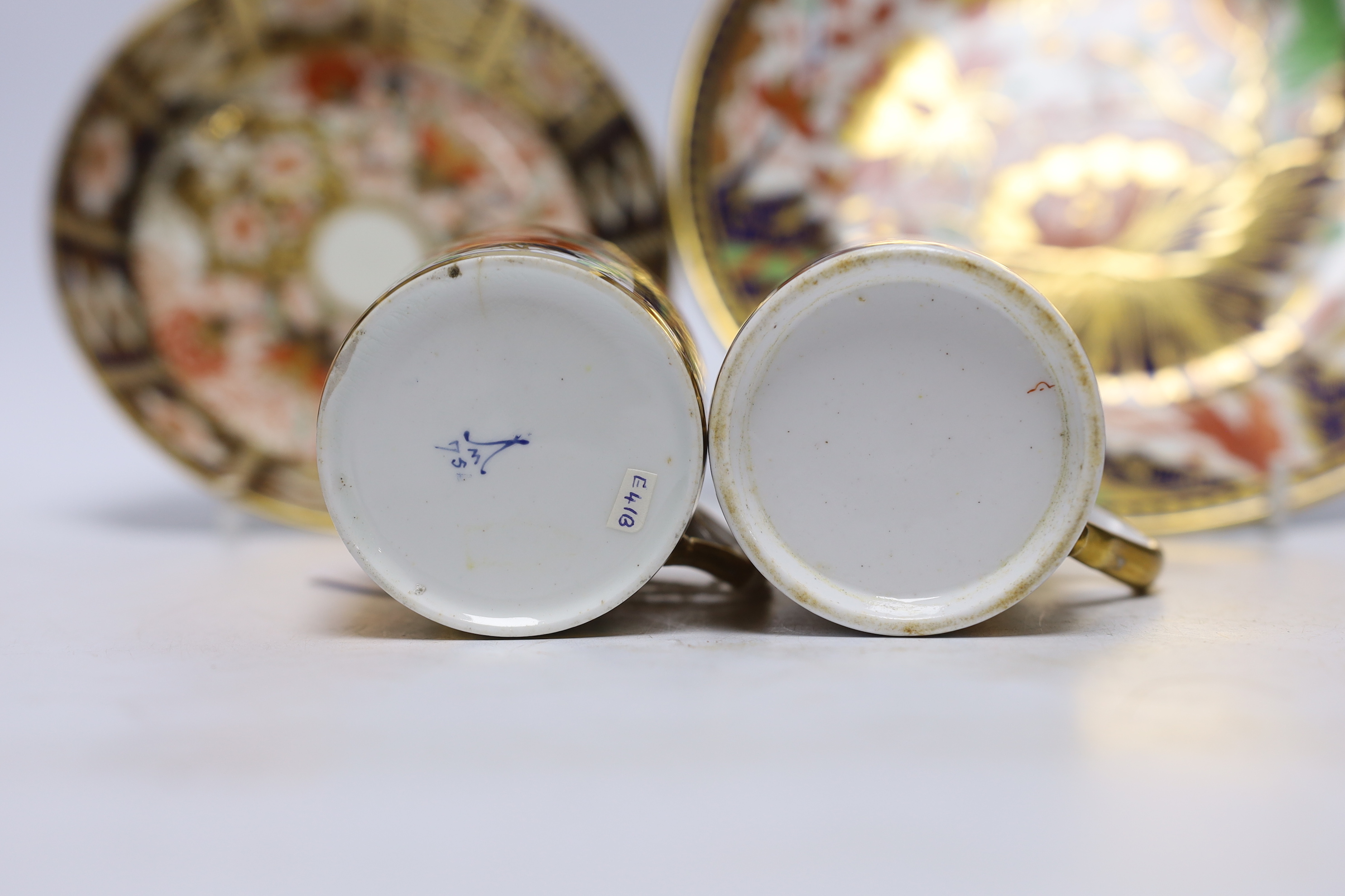 Ten 1800-1820 English porcelain coffee cans, including Imari pattern examples, one with matching saucer, together with a side plate (12)